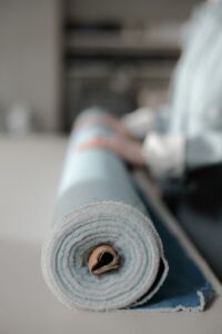 A rolled blue fabric with a blurred background, emphasizing texture and design focus.